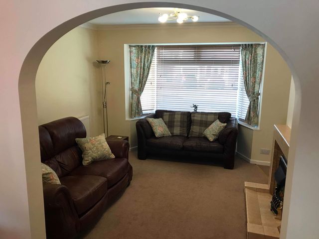 A living room with a sofa and armchair at Lavender Harmony House in Swindon