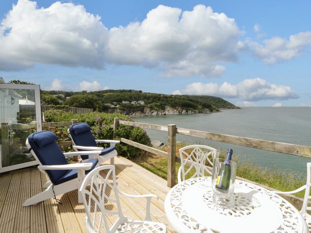 An outdoor seating area with chairs and a table at Clifftop Carriage, Aberporth, Ceredigion