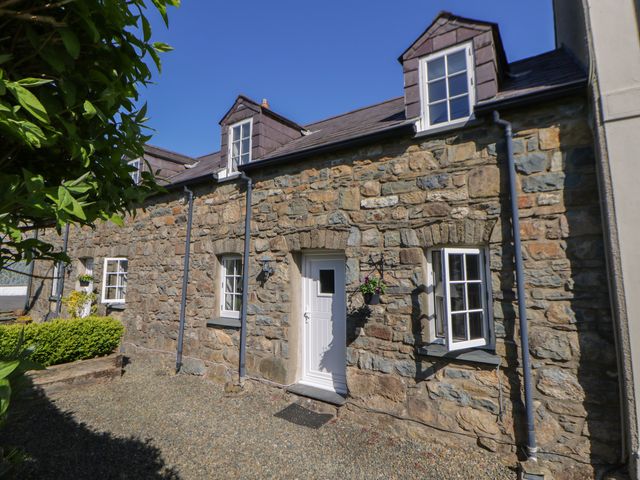 A stone exterior with windows and a door at Middle Cottage in Newport, Pembrokeshire