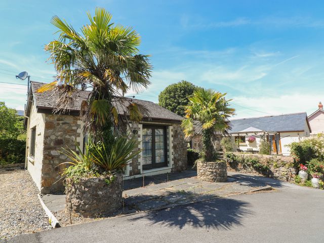 An exterior view of a stone house with palm trees at Stoney Cottage in Narberth, Pembrokeshire