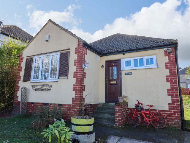 A house with a red bicycle and flower pots at Hira's Cottage