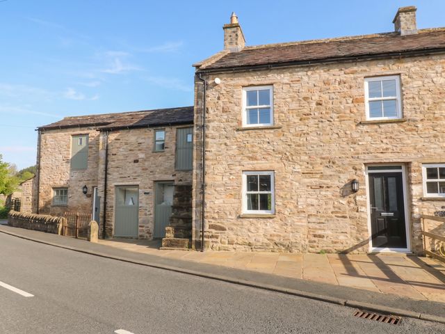 An exterior view of a stone house with windows and a door at White Lea in Reeth