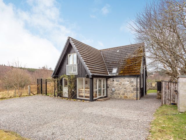 A house with a gravel driveway and leafless trees at Inshcraig in Kincraig near Aviemore