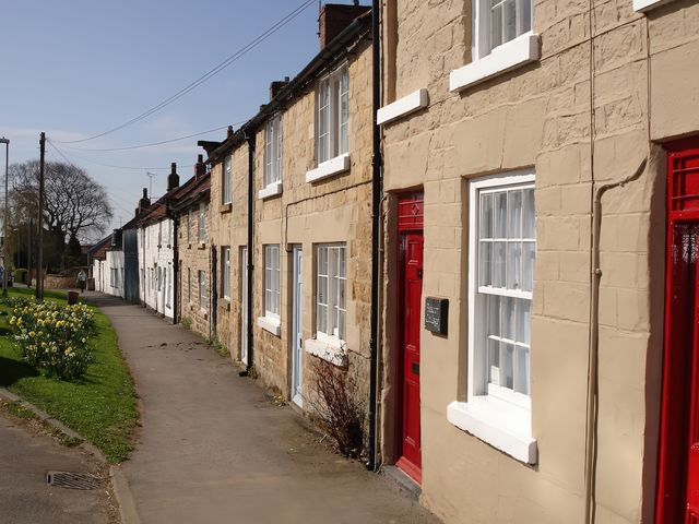 A row of houses with red doors and white windows at Beacon Cottage in Pickering