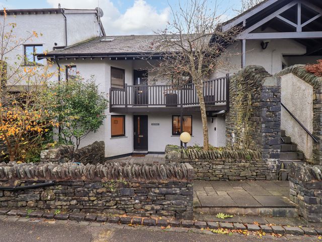 A building with a balcony and stone wall at Gillybeck in Ambleside