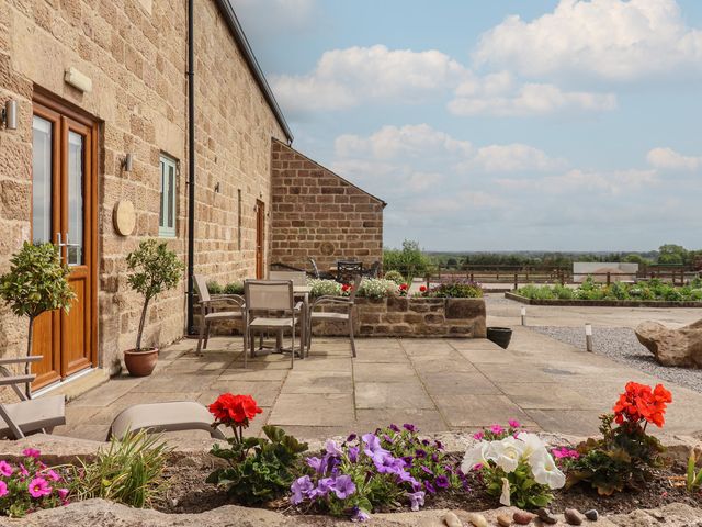 An outdoor area with seating and flowers at Miller's Wheel in Spofforth