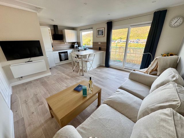 A living room with a kitchen area at Gecko Beach in Porthtowan