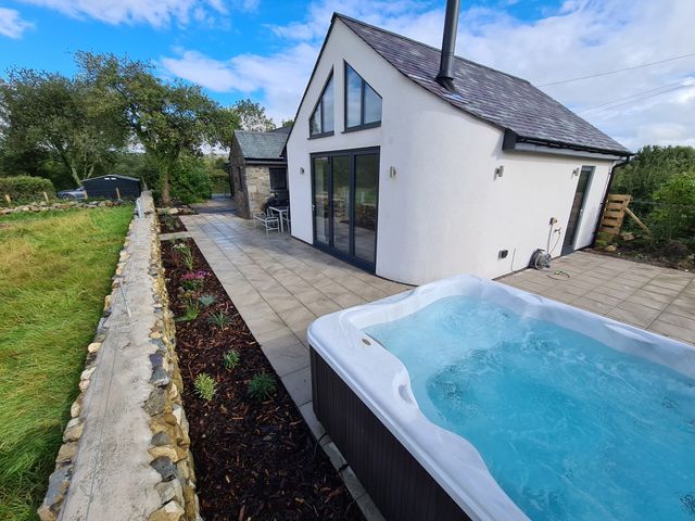 A modern house with a patio garden and hot tub at Pen Y Cefn in Pen Y Cefn