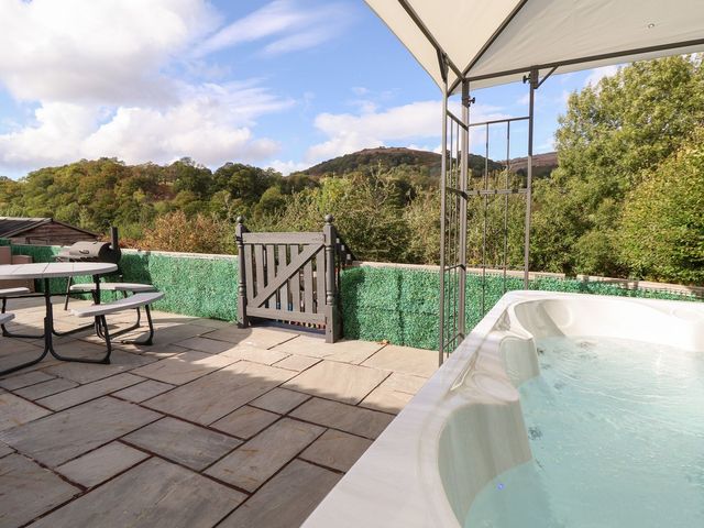 An outdoor area with a hot tub and patio furniture at Castellolwg
