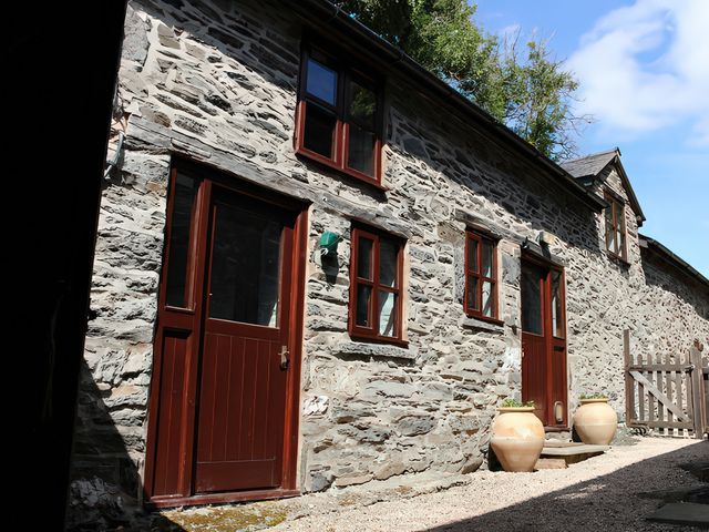 An outdoor view of stone walls and doors at Graig Las The Barn in Llangynog near Llanrhaeadr-Ym-Mochnant