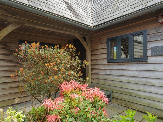 An entryway with wooden walls and roof with shrubs in front at Stow Cottage in Davidstow near Camelford