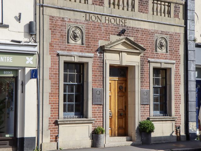 A building facade with a wooden door and windows at Lion House in Moretonhampstead