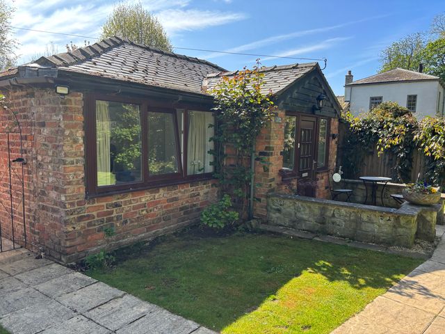 An outdoor area with a brick building and seating at Claire Cottage in Gateforth near Hambleton, North Yorkshire