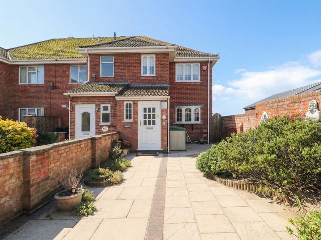 A house with a front door and pathway at Breaking Waves in Burnham-On-Sea