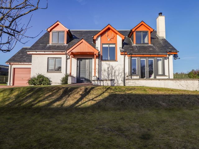 A house with a garage and multiple windows at 3 Croftside Aviemore