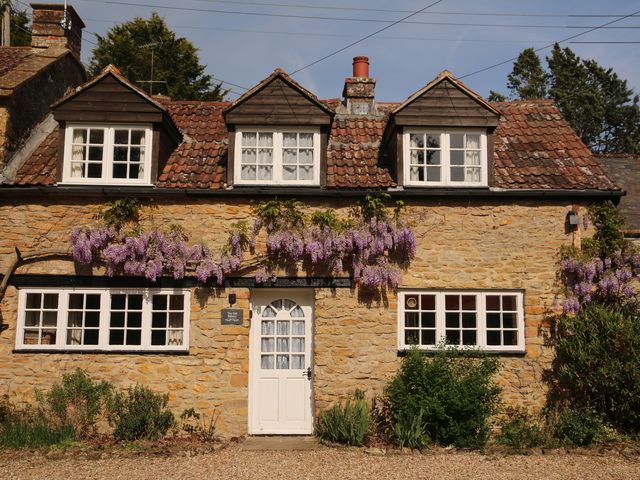 A house with windows and door surrounded by wisteria at The Old Bakery in South Perrott near Mosterton