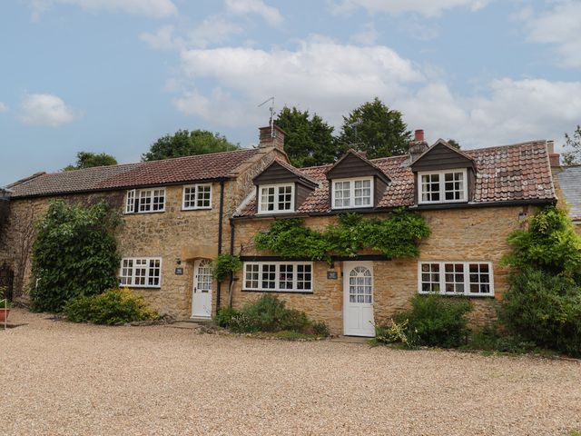A house with multiple windows and a gravel path at The Old Bakery in South Perrott near Mosterton