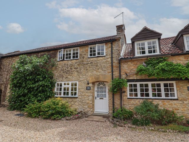 A house with a stone exterior and windows at Jasmine Cottage in South Perrott near Mosterton
