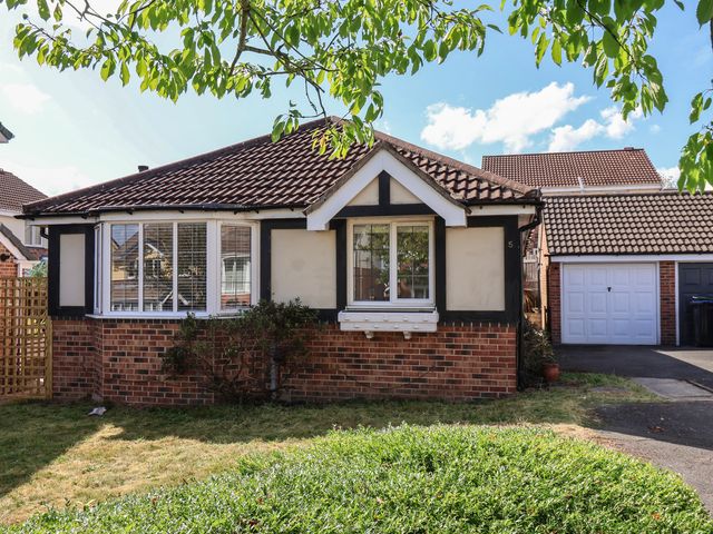 A house with a front garden and garage at 5 Harebell Close in Harrogate