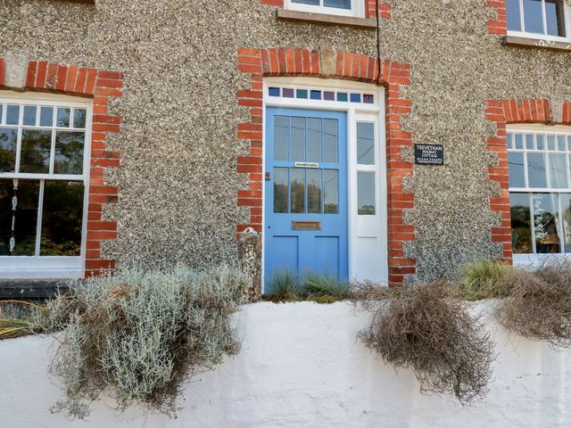 A blue door and window on a stone wall at Trevethen Cottage Crantock