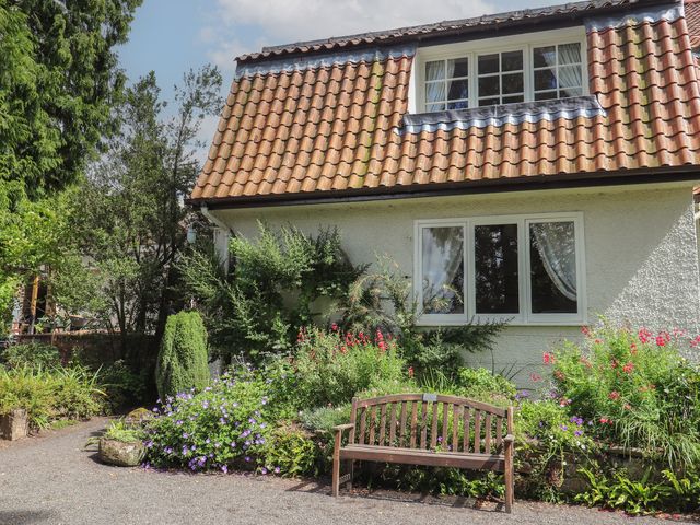 A house with a garden and bench at Branklyn Garden Cottage in Perth