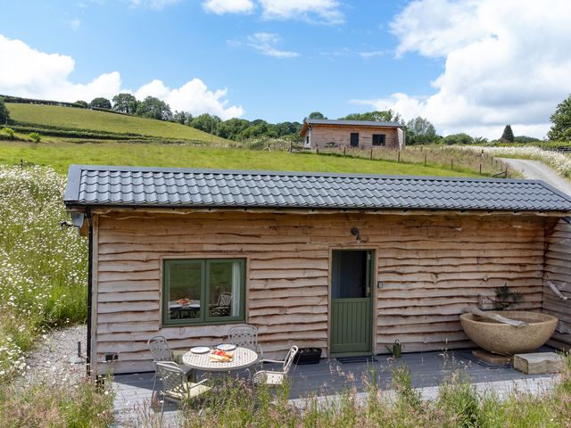 A cabin with a table and chairs at Birch Banc Retreats - Bedw Llanidloes