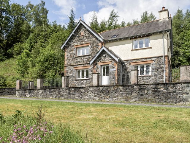 A house with stone walls and a grassy area at Cunsey Lodge at the Graythwaite Estate near Hawkshead