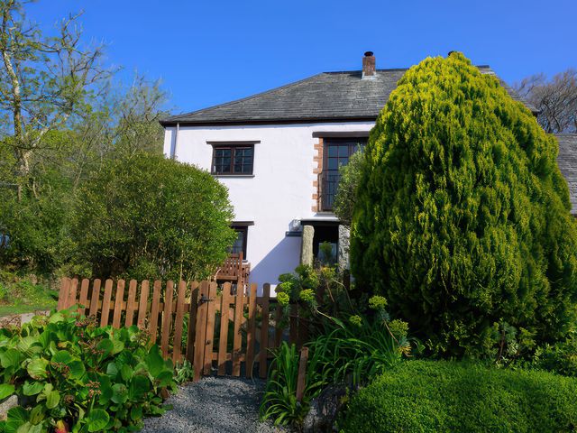 A house with a window and a wooden fence at Beech Cottage in Warbstow