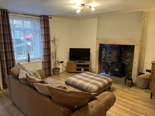 A living room with a sofa and television at Bracken Cottage in Stanhope