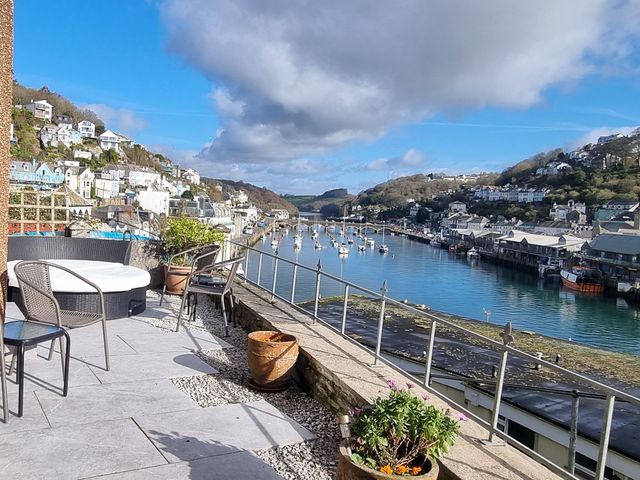 An outdoor area with furniture overlooking a river at Albany in Looe