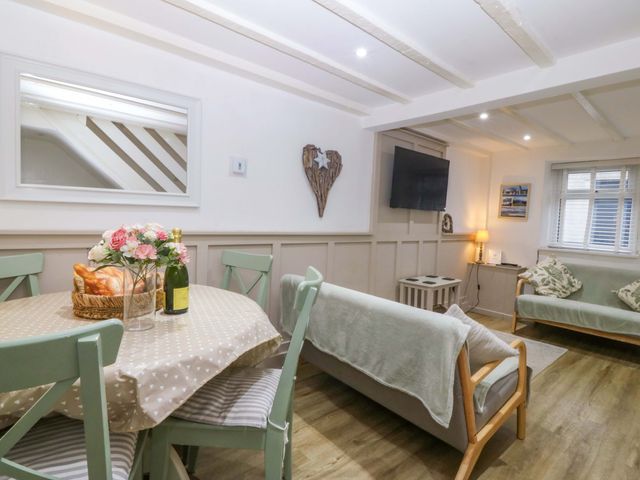 A living room with a dining table and sofa at 27 Kingshead Street Pwllheli