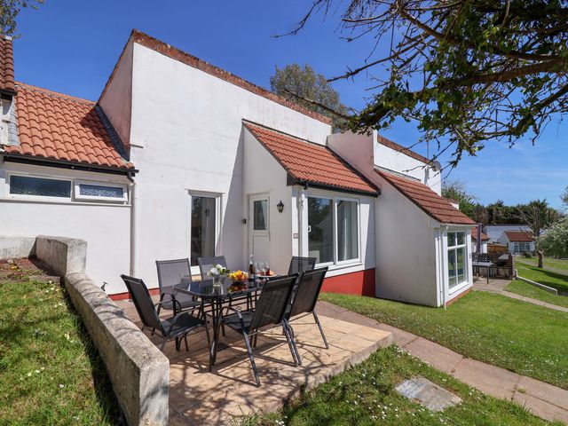 An outdoor area with a table and chairs at 13 Manorcombe Bungalows in Honicombe Holiday Village near Gunnislake