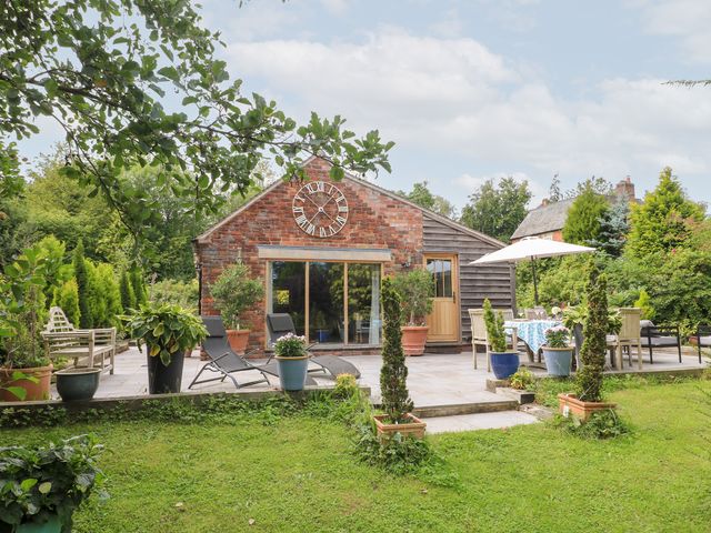 A garden with a brick building and outdoor furniture at Ladycroft Barn Ashbourne