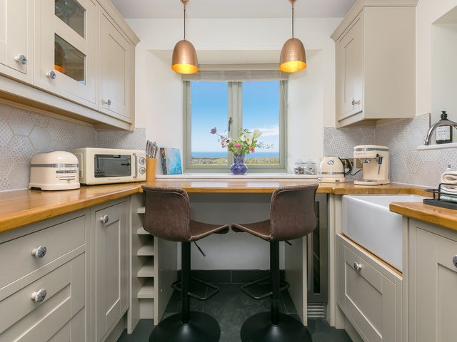 A kitchen with a sink and microwave at Scilly Stack in St Just