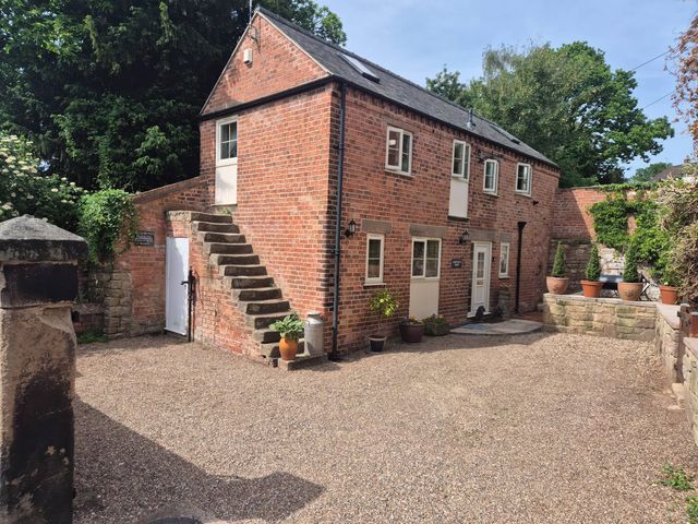 An outdoor area with a brick house and potted plants at Chestnuts Barn Holbrook, Derbyshire