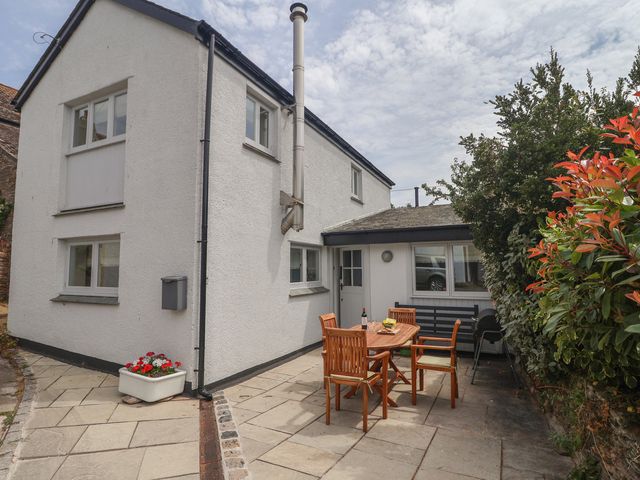An outdoor area with a table and chairs at Wrens Nest in Slapton