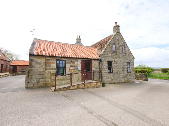 A house with a red roof and stone walls at Albany @ Summerfield Farm in Hawsker