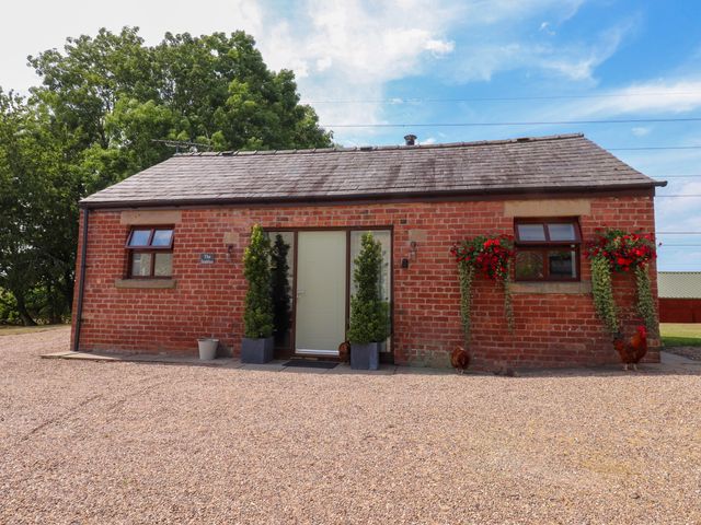 A brick building with a door and windows at The Stables Hall Green near Walmer Bridge