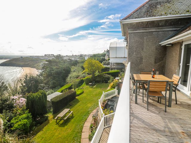 A balcony with a table and chairs overlooking a garden at Tremorna Vista in Carbis Bay