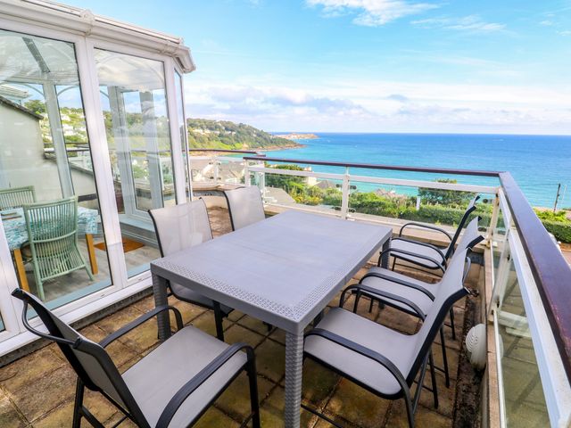 An outdoor terrace with a table and chairs at Ocean Gem in Carbis Bay