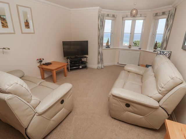 A living room with a sofa and television at Golva in Carbis Bay