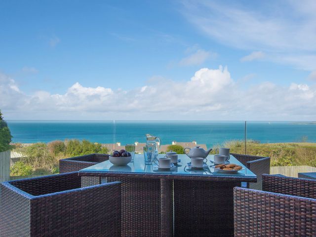 An outdoor dining area with a table set for tea at Halcyon Cove in Carbis Bay