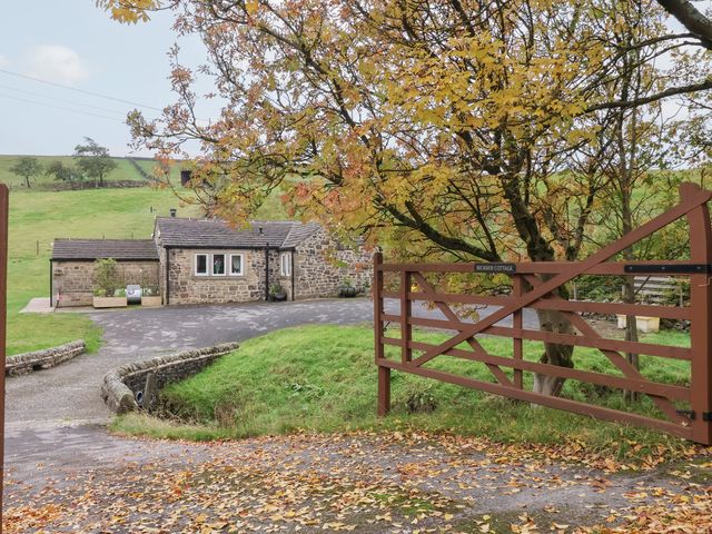 A cottage with a stone exterior and gate at Beckside Cottage in Cowling near Skipton