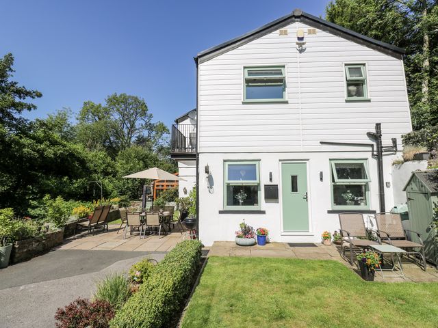 A house with a garden seating area and patio at Springhead Cottage in Haworth