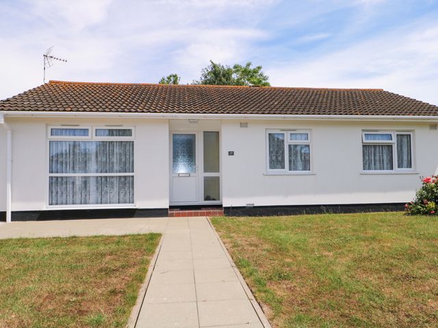 A bungalow with a pathway and garden at Dymchurch Bungalow in Romney Marsh