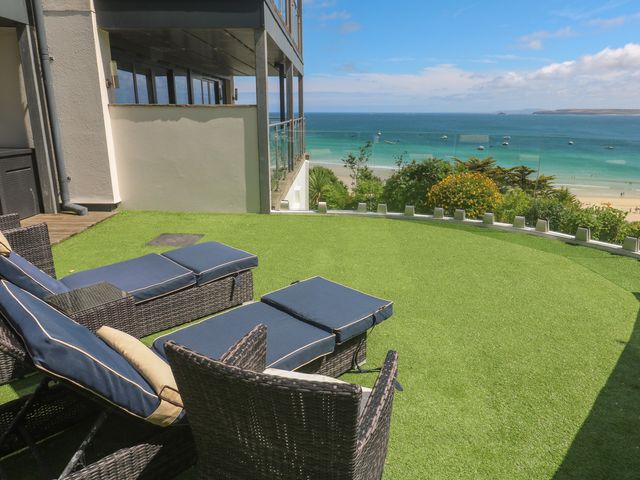 An outdoor area with chairs and an ocean view at Peninsula Apartment 2 St Ives