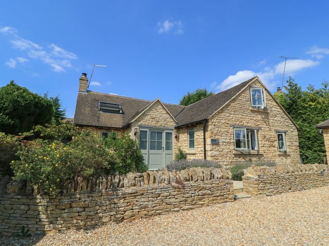 A house with stone walls and a gravel drive at 12 Manor Farm Close Kingham