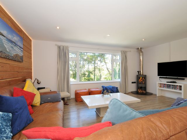 A living room with a sofa and a television at Beaches in Polzeath