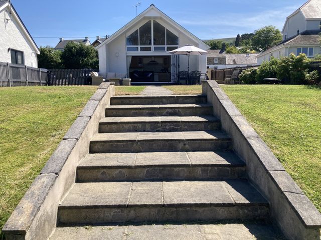 A garden with steps leading to a patio at Awel Deg, Newport
