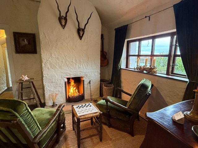 A living room with a fireplace and seating area at The Captain's Nest in Bunbeg, County Donegal